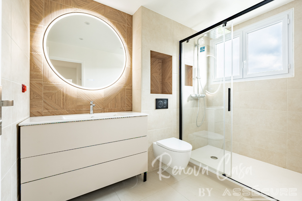 Salle de bains rénovée à Antony : douche vitrée, meuble suspendu et miroir lumineux